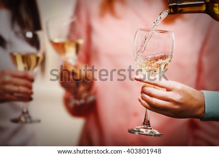 Pouring white wine into glass at hen-party, close up