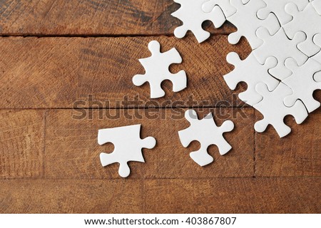 Incomplete puzzles on wooden table