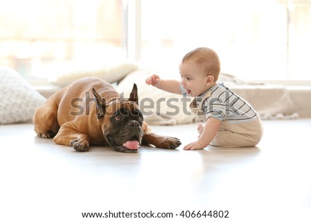 Little baby boy with boxer dog on the floor at home
