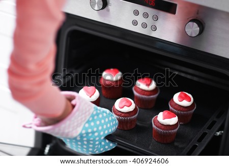 Woman baking cupcakes in the oven