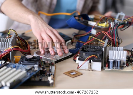 Young man repairing computer hardware in service center