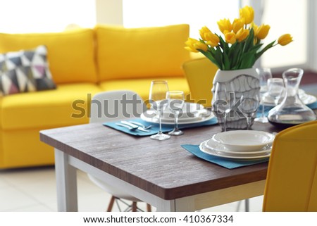 Dining room interior with sofa and table served for dinner