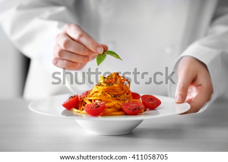 Chef hands preparing delicious cold pasta salad on the table closeup