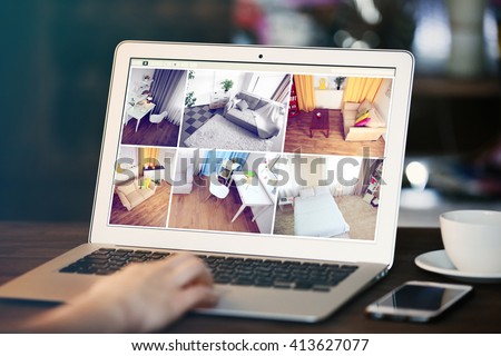 Woman monitoring home security cameras on laptop. Home security system concept