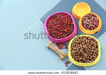 Pet food in  bowls on a floor.