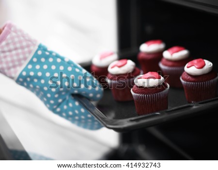 Woman baking cupcakes in the oven