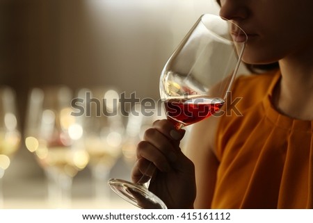 Woman sniffing red wine in a glass, close up