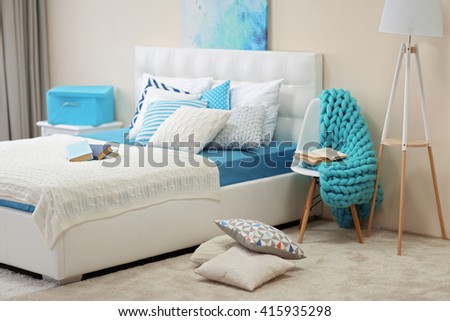 Bedroom interior in light tones with white furniture and pillows