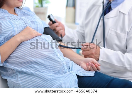 Doctor measuring pressure of the pregnant woman
