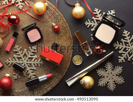Colorful makeup cosmetic with Christmas decoration on golden beaded mat