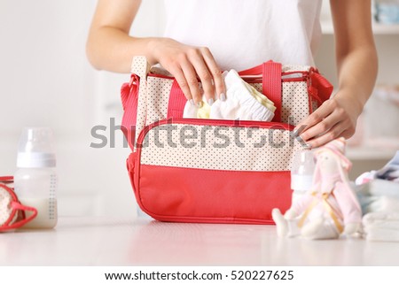 Woman packing her bag with child stuff