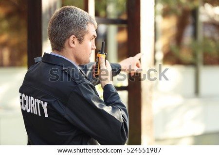 Male security guard near building facade