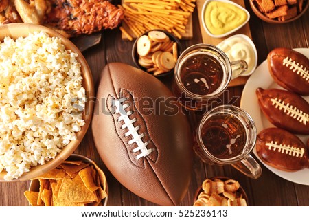 Table full of tasty snacks and beer prepared for watching rugby on TV