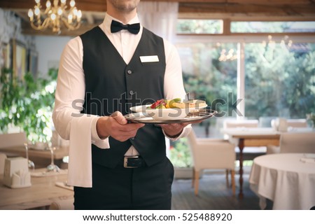 Waiter serving salad at restaurant, close up view
