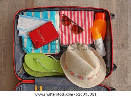 Open suitcase packed for travelling, close up