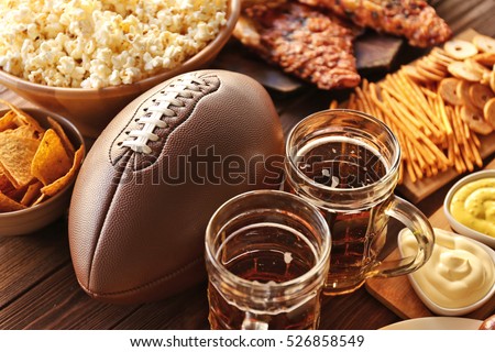 Table full of tasty snacks and beer prepared for watching rugby on TV