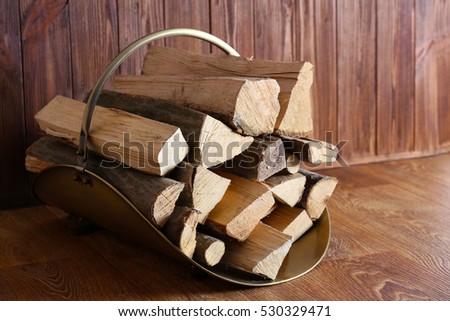 Basket with firewood on wooden background