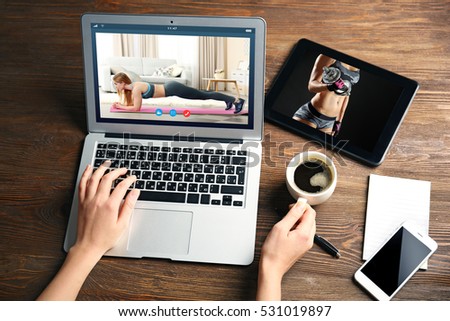 Woman watching sport training online on laptop. Fitness and sport blog.