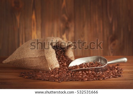Purse with roasted coffee beans on wooden background