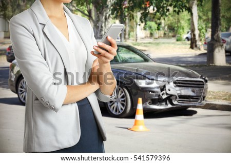 Woman using phone after car accident, closeup. Traffic safety concept.