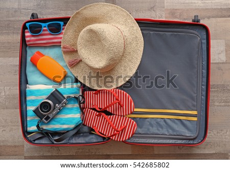 Open suitcase packed for travelling, close up