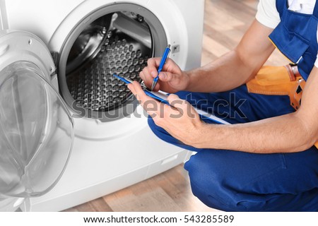 Plumber with clipboard near washing machine