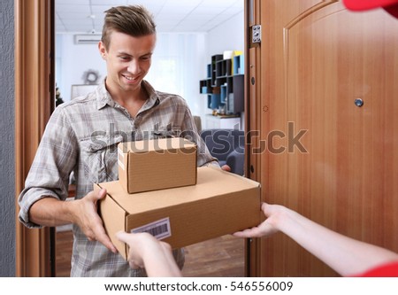 Young man receiving package from courier