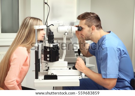 Ophthalmologist measuring intraocular pressure of young woman in clinic