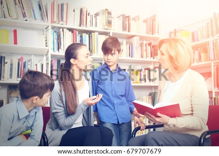 Teacher and mother with sons on meeting at school library