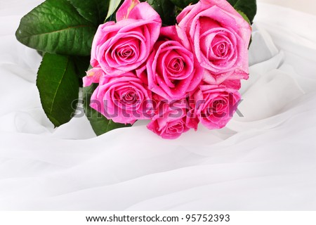 Many pink roses in a white cloth isolated on white