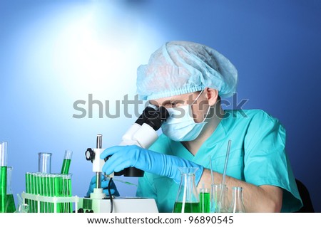 scientist looking at microscope in chemistry laboratory