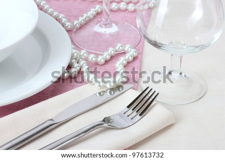 Table setting with fork, knife, plates, beads and napkin