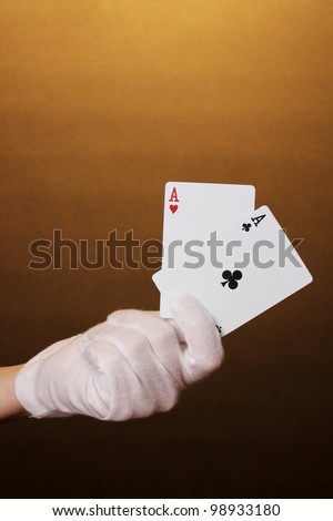 Cards in hand on brown background