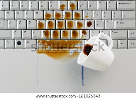 Coffee spilled on keyboard, close up shot. Damaged computer that needs reparation. Data safety and laptop insurance concept.