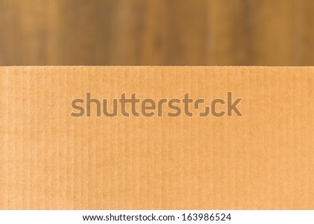 Corrugated cardboard on blurry brown background