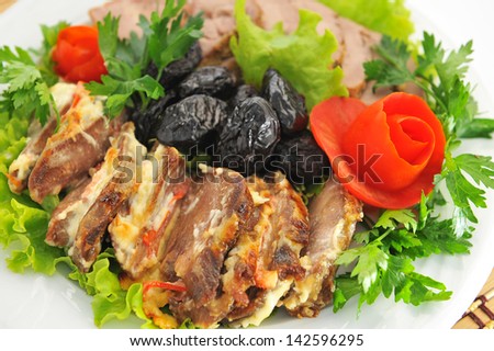 Meat, cut into slices beautifully decorated with lettuce and tomato.