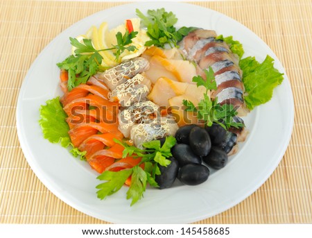 Sliced  ??salmon, herring, sturgeon, decorated with green olives lemon.