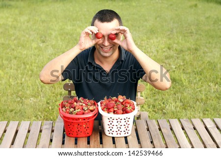Funny man eating strawberries