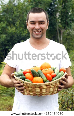 Portrait of smiling farmer holding vegetables basket