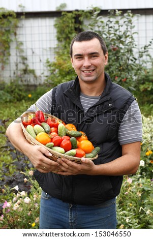 Smiling farmer holding vegetables basket