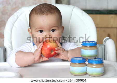 baby  with food. apple and  jars