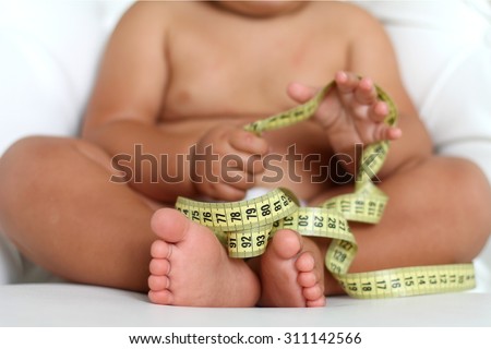 Adorable Baby Boy with a measuring tape