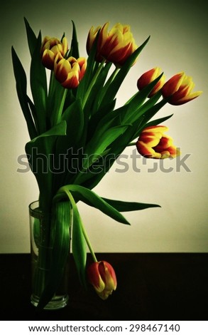 bouquet of yellow and orange tulips with green leafs, with grain texture