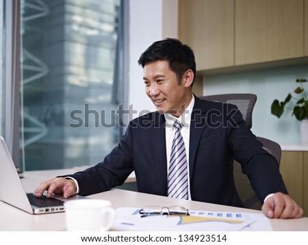 asian businessman working on laptop in office.