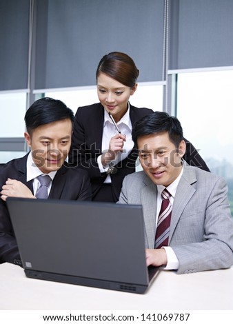 a team of asian business people working together in office.