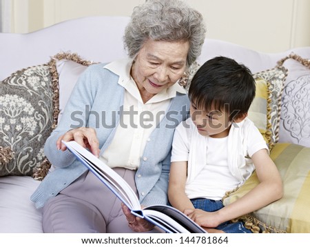 grandma and grandson reading a book together.
