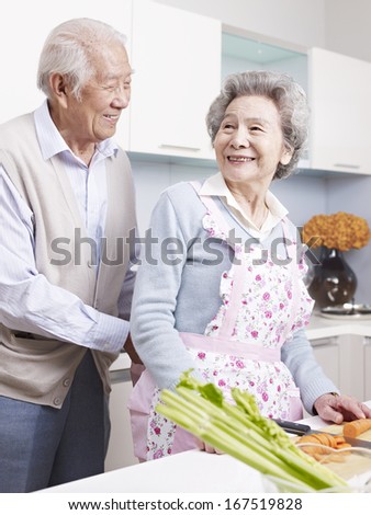 senior man tying apron for his wife.