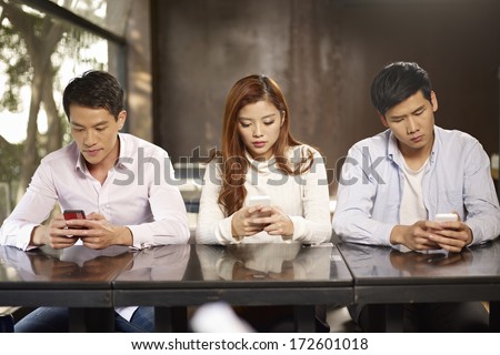young people playing with smartphones and ignoring each other.
