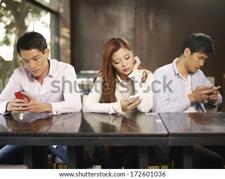 Young People Playing With Smartphones And Ignoring Each Other.