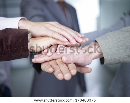business people putting hands together to show unity.